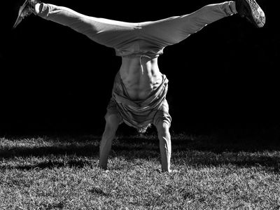 Athletic man in mid-motion transitioning between two bodyweight exercises.