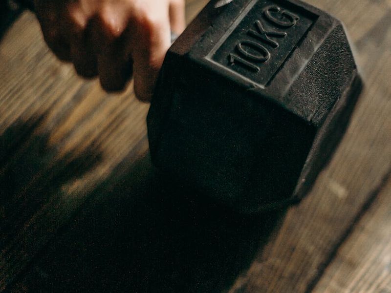 Close-up shot of a man's hands gripping the floor during a plank exercise.